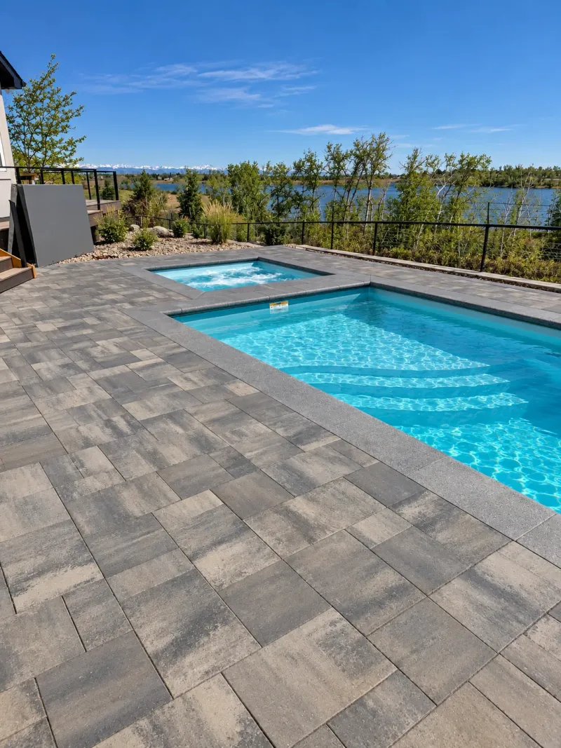 Swimming pool and spa beside a lakeside paver patio